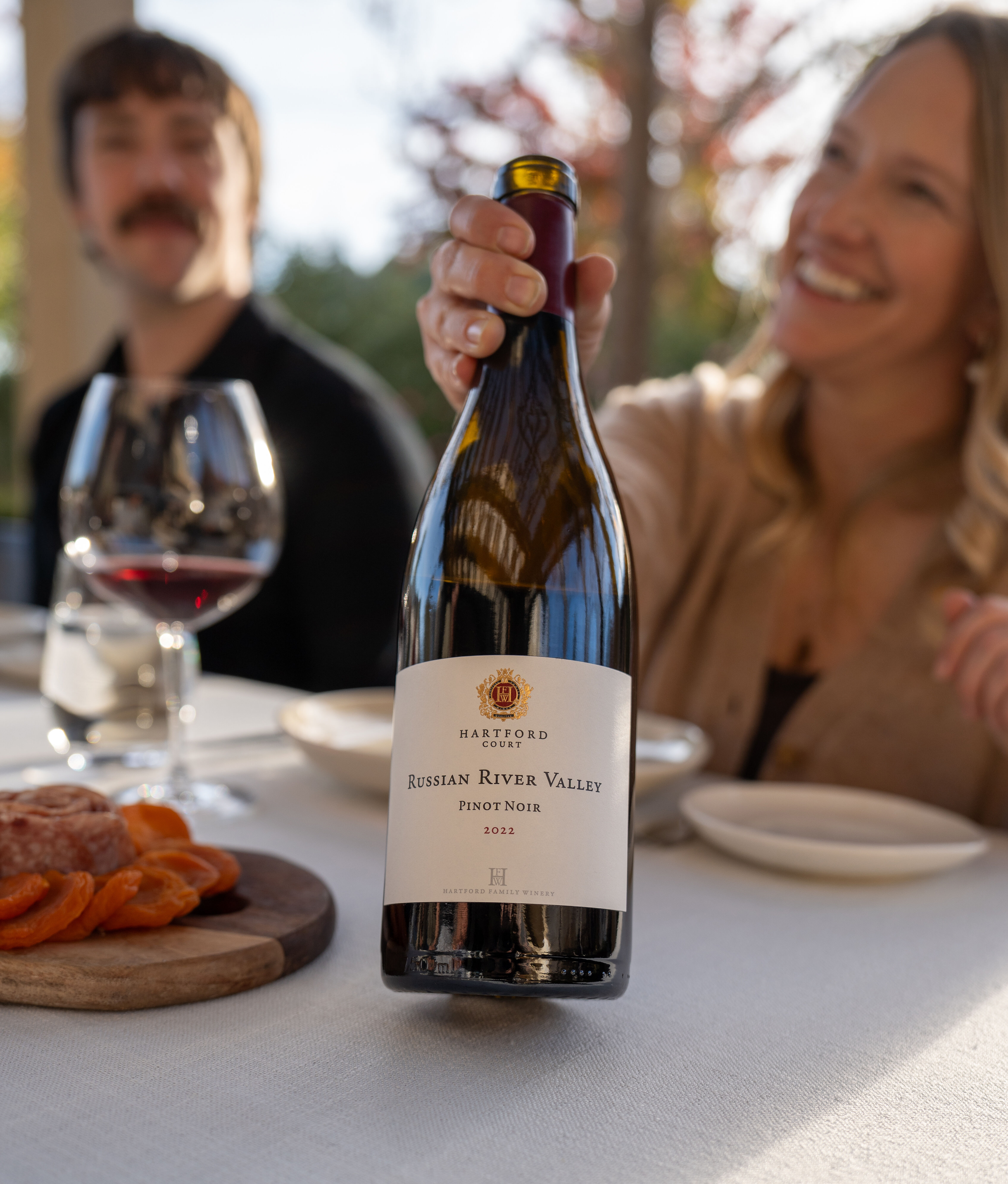 Hailey Hartford holding a bottle of Hartford Pinot Noir